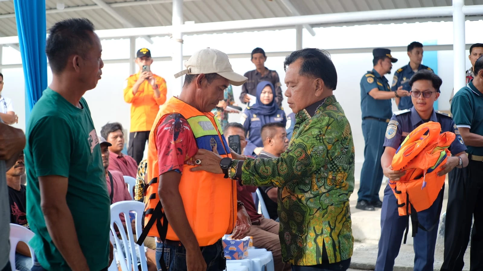Memasangkan secara simbolis life jacket bagi nelayan dan pengusaha kempang