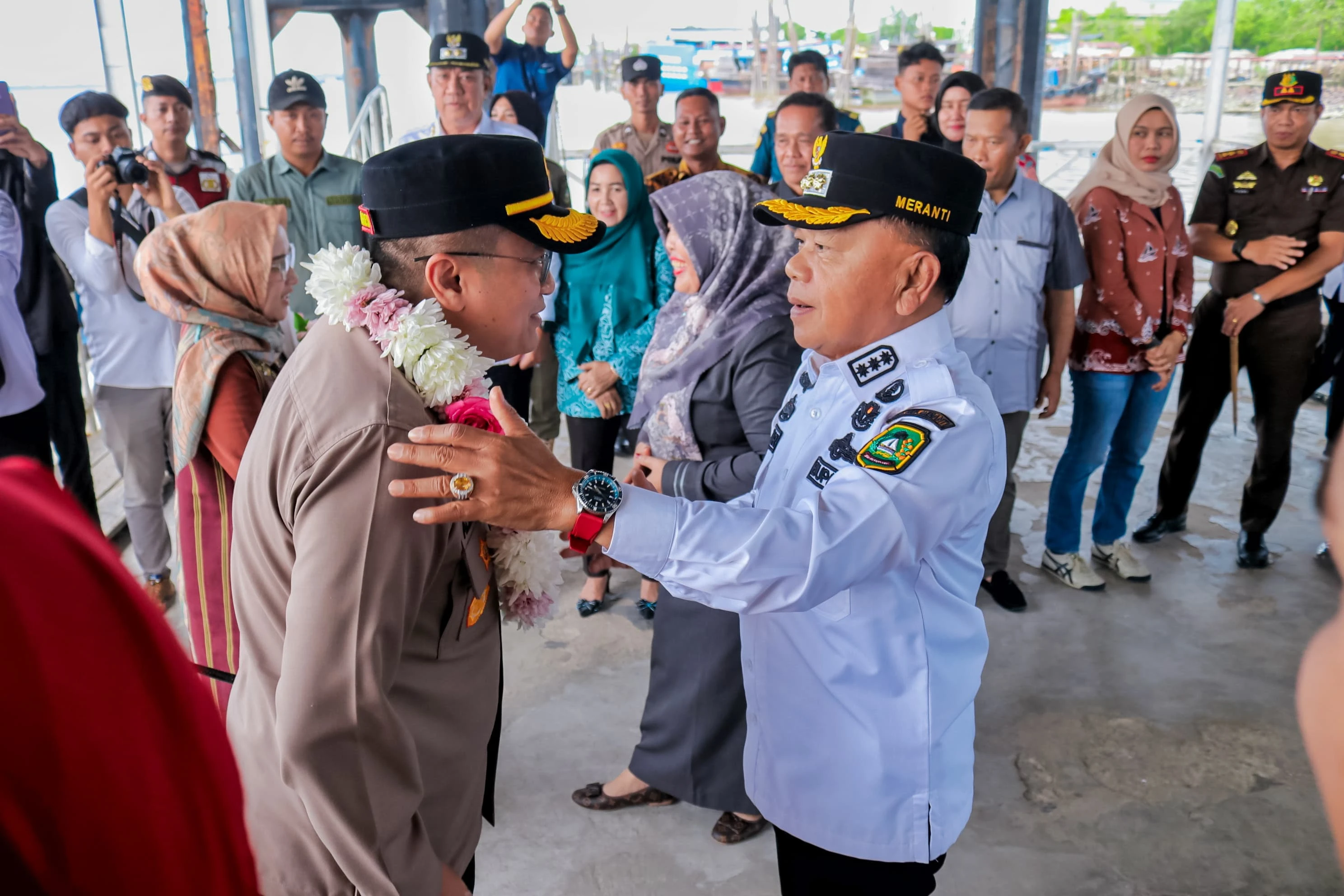 Bupati Kepulauan Meranti H. Asmar mengalungkan bunga pada saat penyambutan Kapolres Kep. Meranti yang Baru di Pelabuhan Tanjung Harapan Selatpanjang.