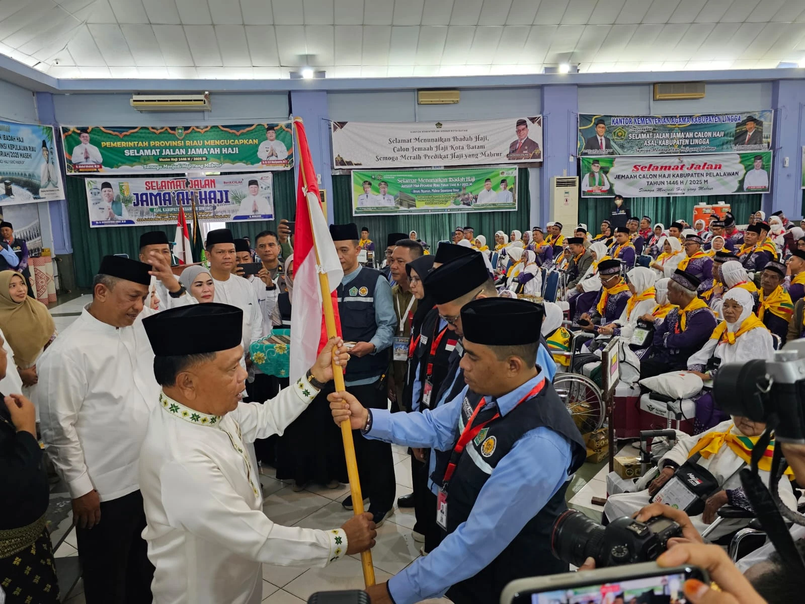 Bupati Kep. Meranti H. Asmar saat menyerahkan bendera Merah Putih tanda pelepasan Jamaah Calon Haji di Asrama Haji Batam.