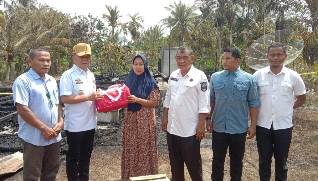 Bupati Meranti H. Asmar saat memberikan bantuan kepada korban kebakaran rumah di Desa Alahair.