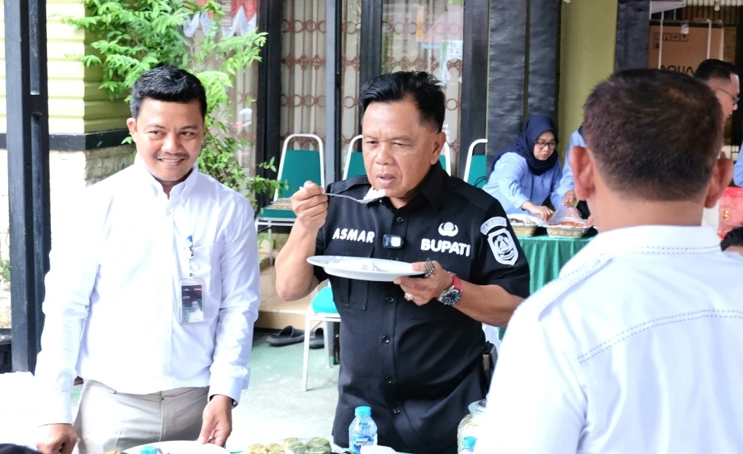 Bupati Meranti H. Asmar saat merasakan Nasi dari beras Bulog SPHP.